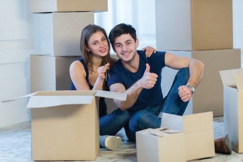 Movers carrying belongings through a stairwell in North London flat